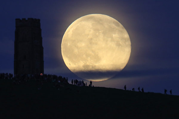 GLASTONBURY, ENGLAND - JUNE 20:  A full moon rises behind Glastonbury Tor as people gather to celebrate the summer solstice on June 20, 2016 in Somerset, England. Tonight's strawberry moon, a name given to the full moon in June by Native Americans because it marks the beginning of strawberry picking season, last occurred on the solstice on June 22, 1967 and it will not happen again on the summer solstice for another 46 years until June 21, 2062.  (Photo by Matt Cardy/Getty Images)