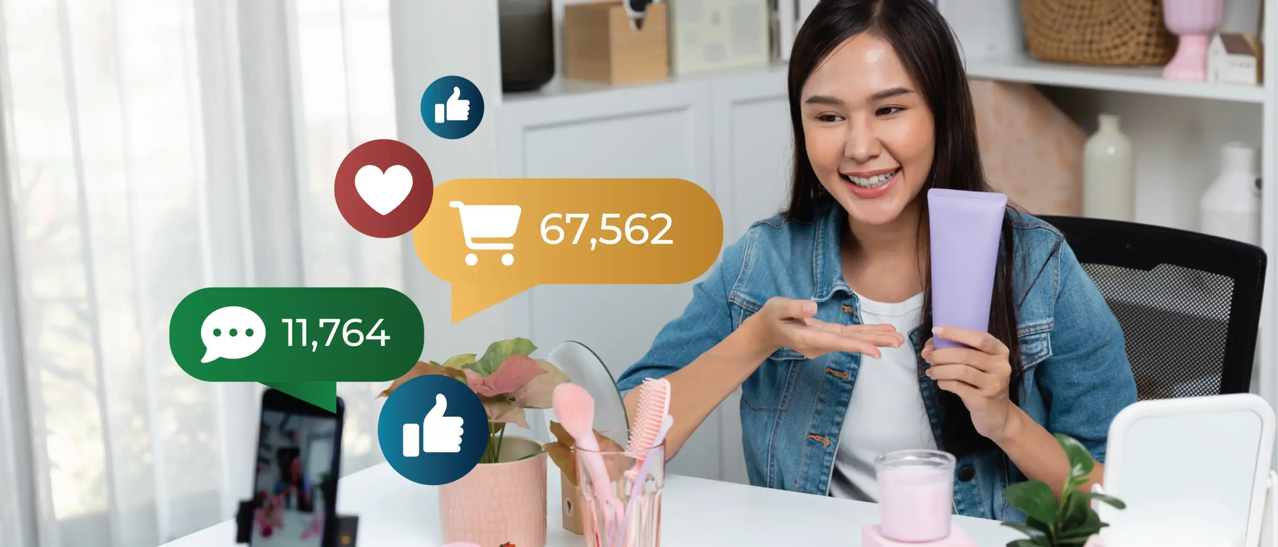 Image of a person in front of a cellphone on a tripod. The person is livestreaming a product demonstration. The image is overlaid with social engagement icons.